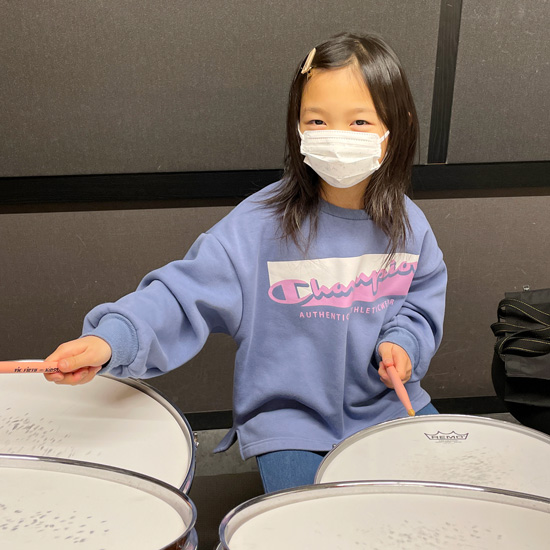 ドラムを叩く女の子の生徒さんの写真